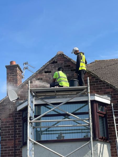 Our team on the tower over the bay, cutting out old joints in the gable