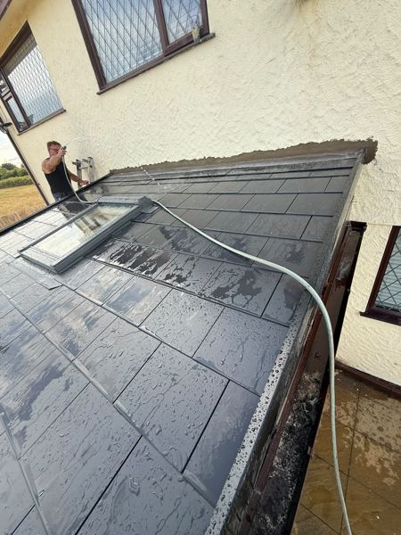 Finished slate-grey conservatory roof being hosed down, roof window in place