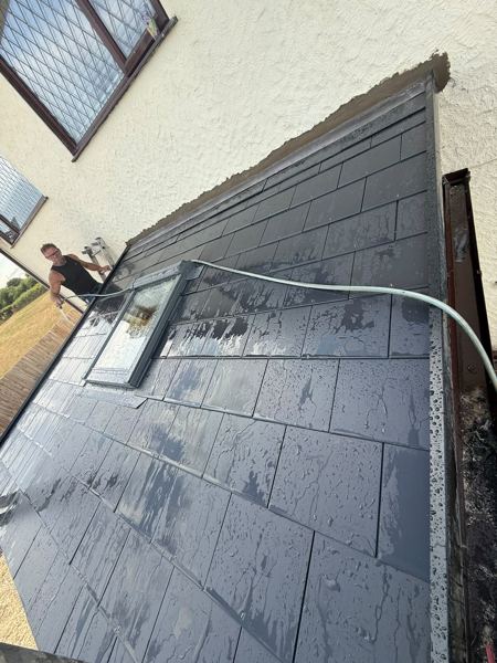 The new tiled conservatory roof seen along its length, wet from rinsing