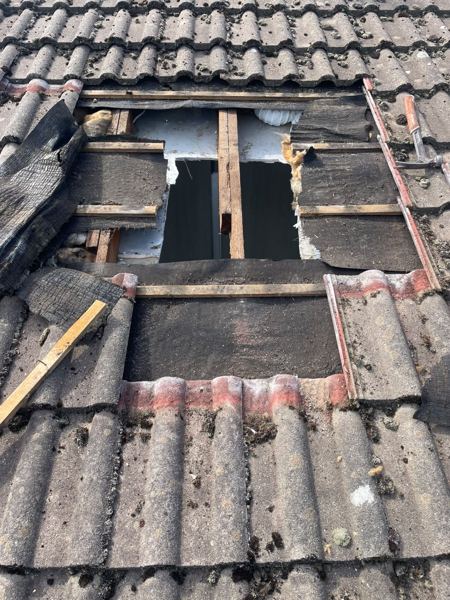 Tiles and battens removed, showing the rafter and insulation through the opening
