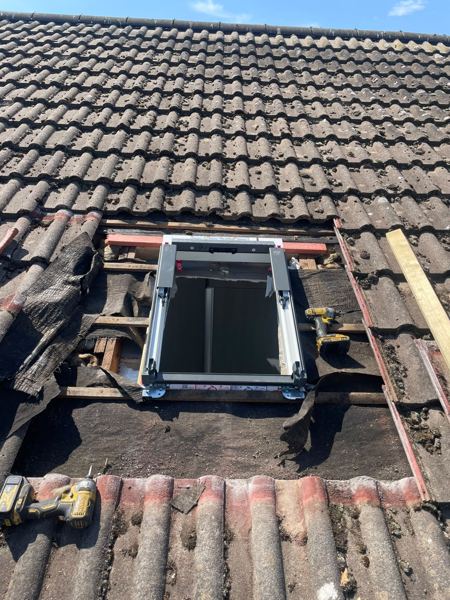 Window frame fixed into the framed opening, battens in place ready for tiles