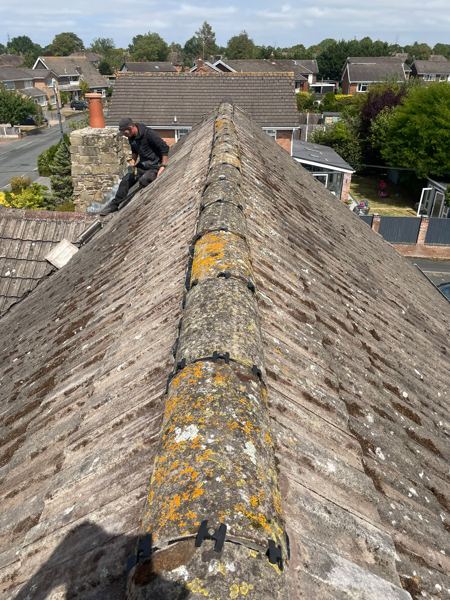 Lichen-covered half-round ridge, with our roofer working by the chimney