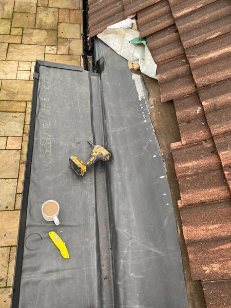 Membrane going down, with drill, knife and tea on the bay top