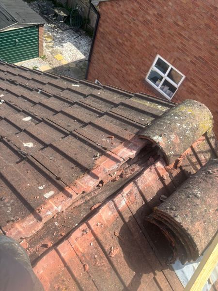 Ridge tiles lifted at the gable end and old mortar broken out