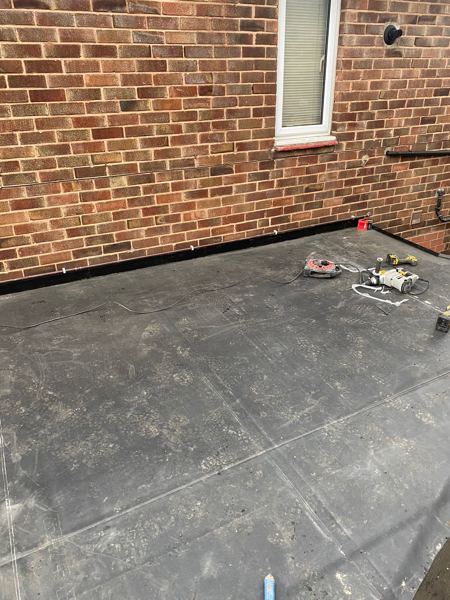 Rubber upstand along the foot of the brick wall