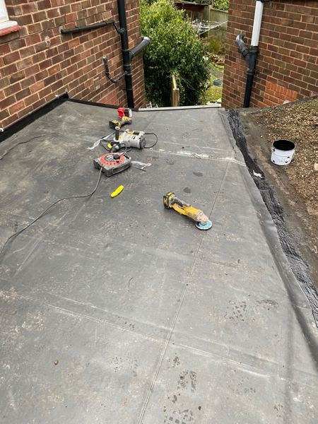 New EPDM roof between two brick walls, tools still on the surface