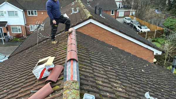 Ridge tiles being fixed over the new dry ridge roll on a concrete tiled roof