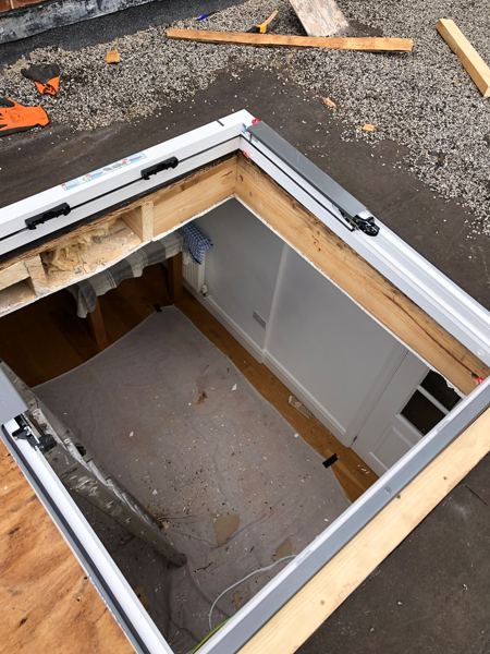 Timber-framed opening with the white skylight frame fixed on top