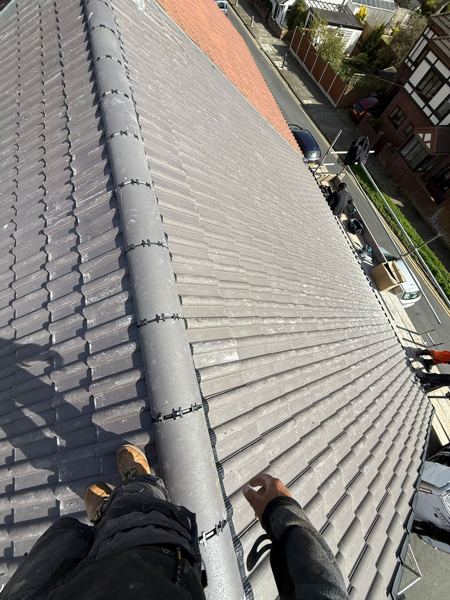 Finished ridge with clipped joints, the neighbour's red tiles beyond