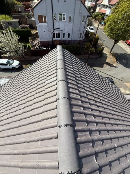New grey concrete tiles with a dry-fixed hip running down the slope