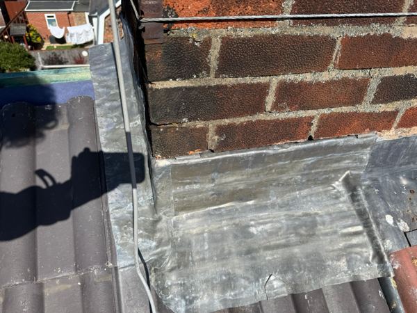 Lead apron at the base of the chimney, stepped into the brickwork
