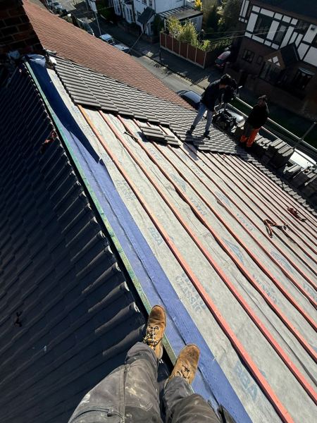 New membrane and battens, with tiles being loaded out on the slope