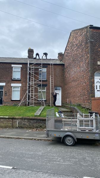 Red brick terrace with a tower, ladders and our roofers at the ridge