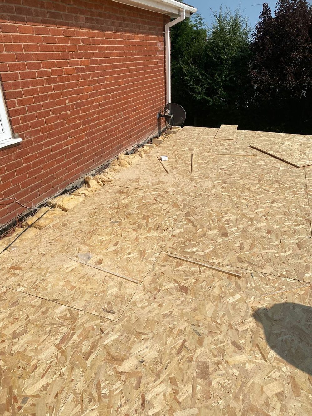A new deck run right out to the edge, with the gap along the wall packed out before the covering goes on