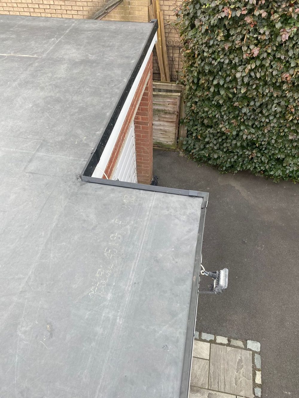 Two finished roofs at different levels, each with its own trimmed edge, looking down on the passage below